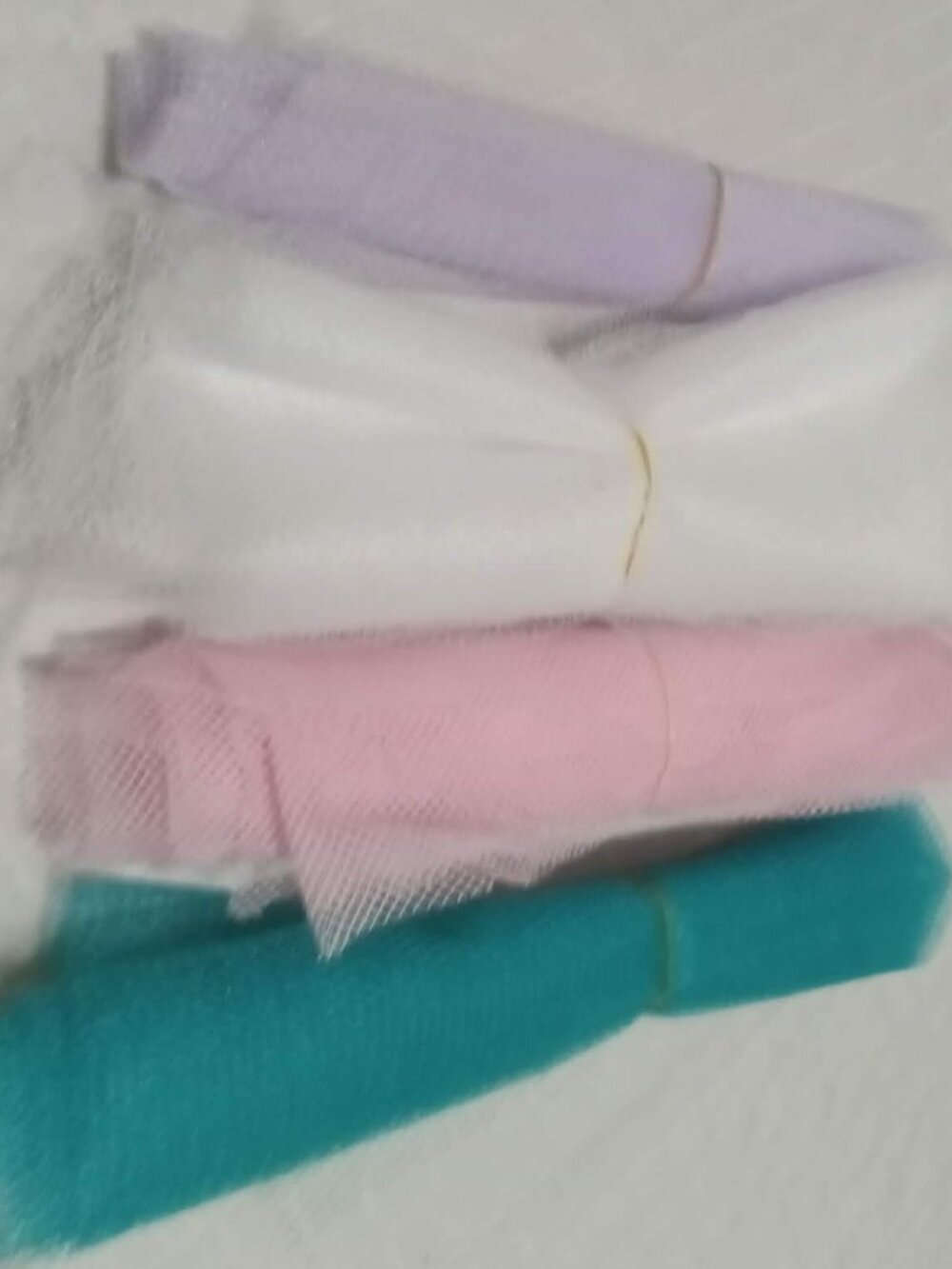 4 lengths of tulle: turquoise, white, pink, and mauve, fabrics